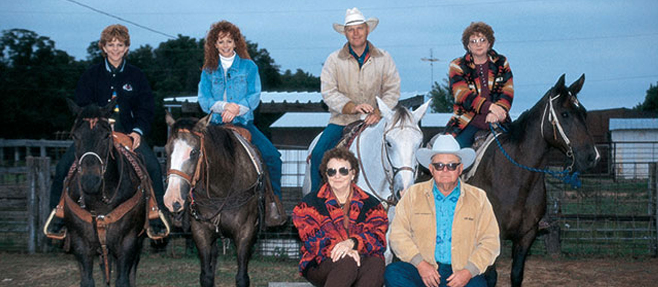 Reba McEntire and her family posing horseback at their family ranch in Oklahoma.